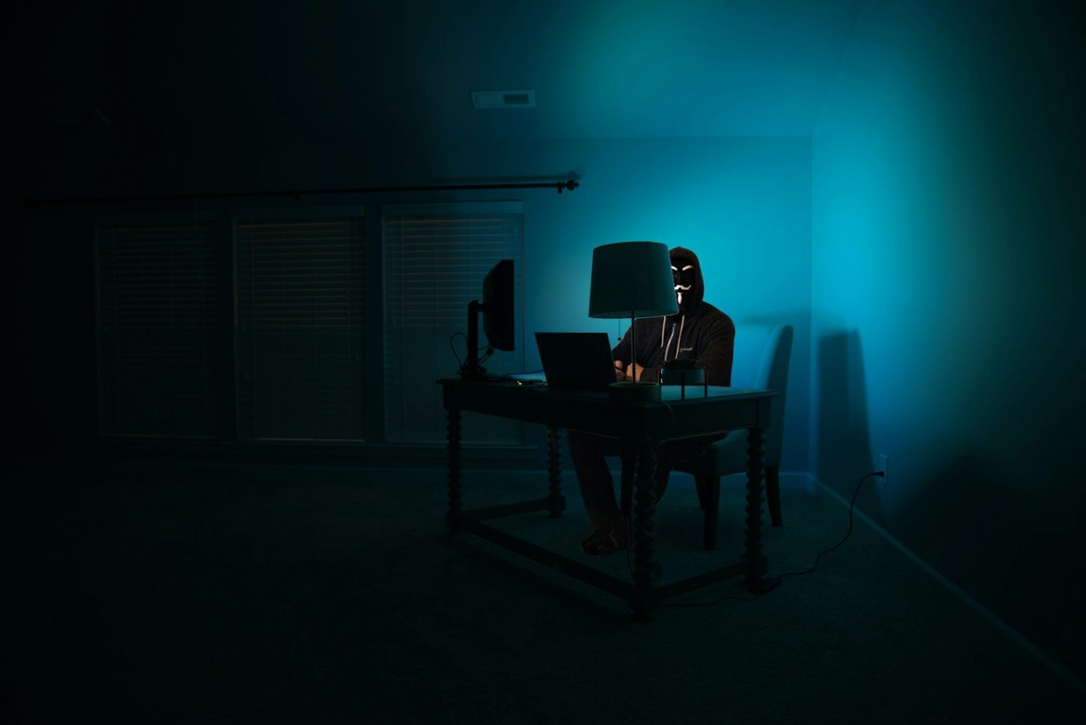 a person sitting at a desk in a dark room